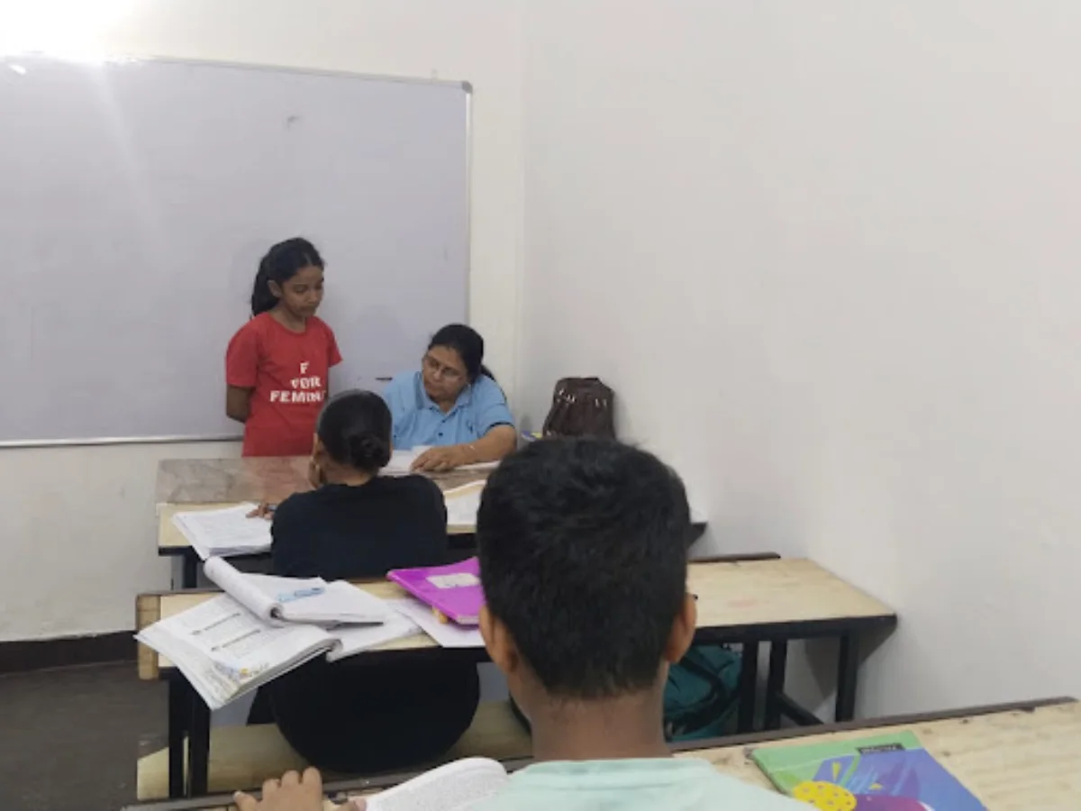 Teacher helping a student at the whiteboard at Nipun Coaching